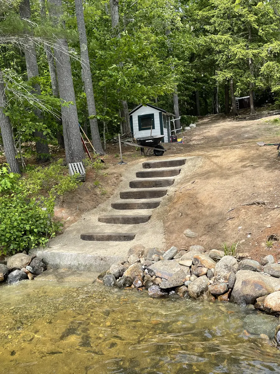 Rebuilt stone steps leading down to the water at a lakefront camp