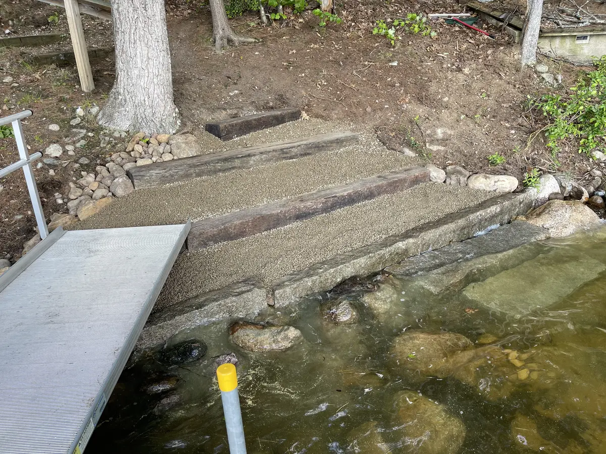 Finished stone shoreline steps beside a dock