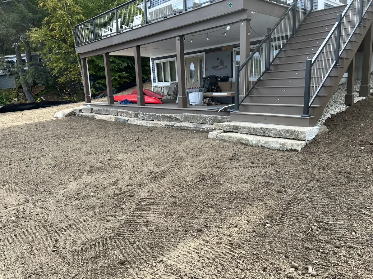 Finish-graded ground around an elevated home ready for landscaping