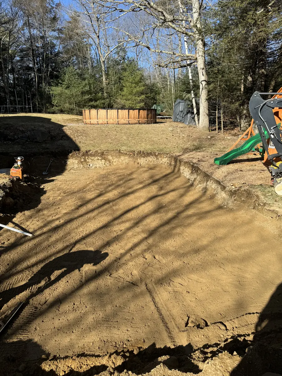 Foundation hole excavated to depth on a wooded building lot