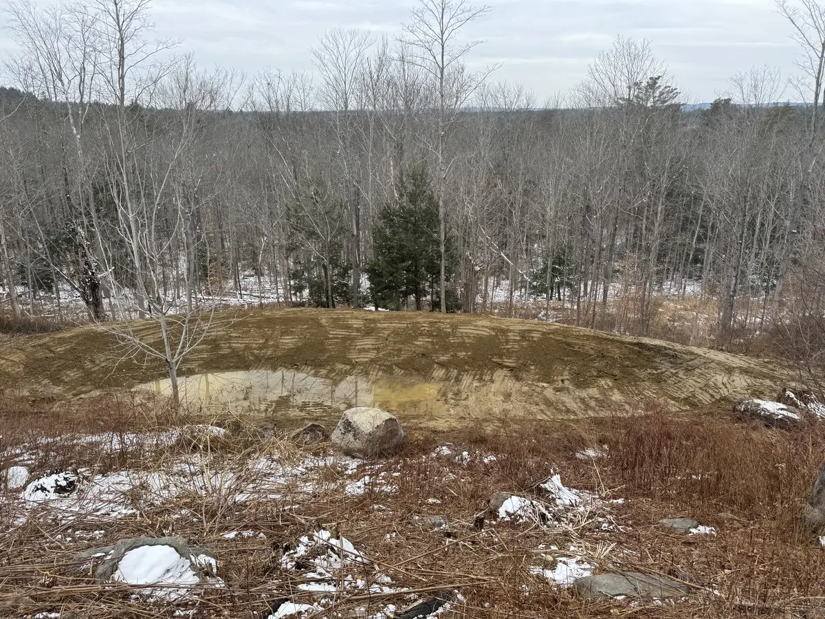 Snow-dusted earthwork site in a southern Maine winter