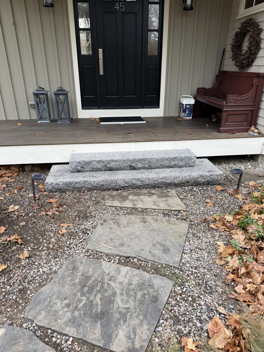 Granite front steps set into a walkway with stone landing