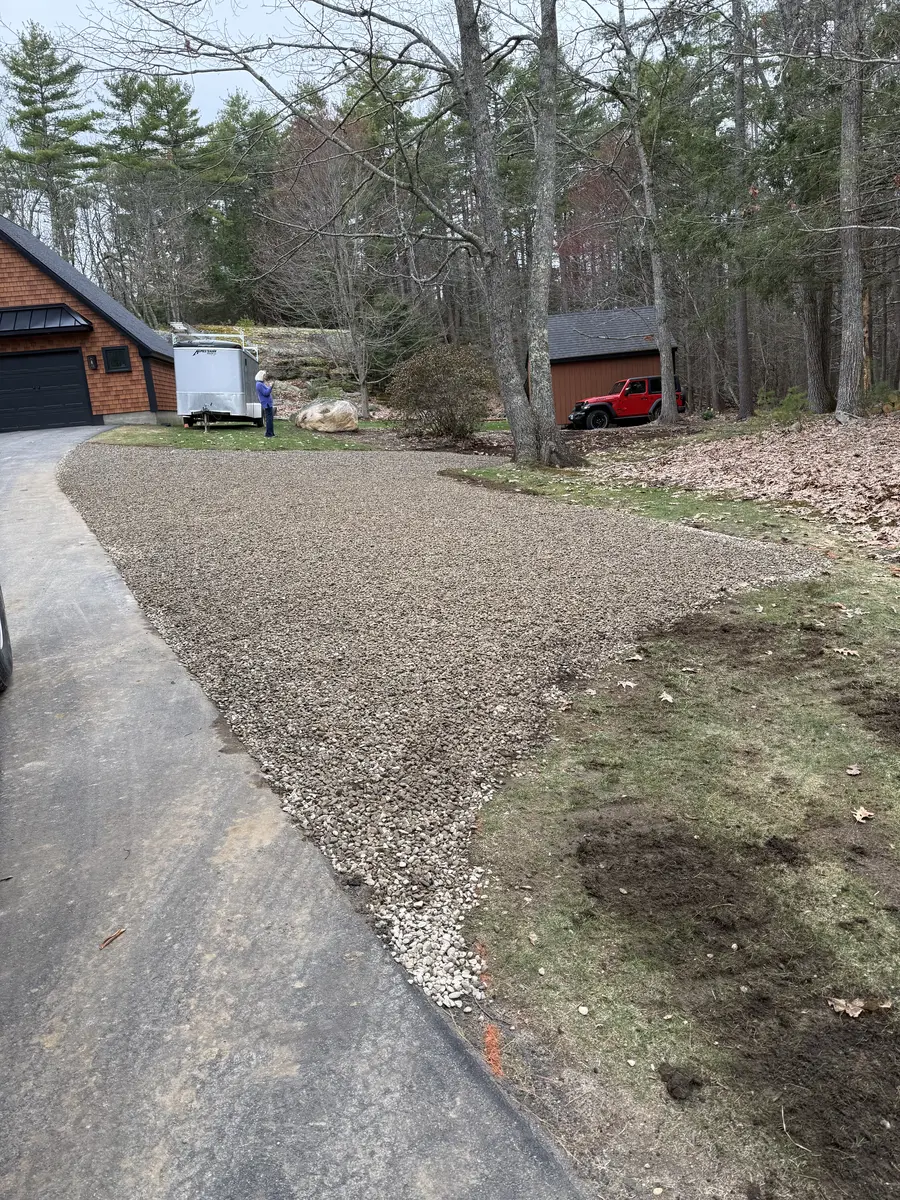 Fresh crushed gravel driveway apron meeting the paved road