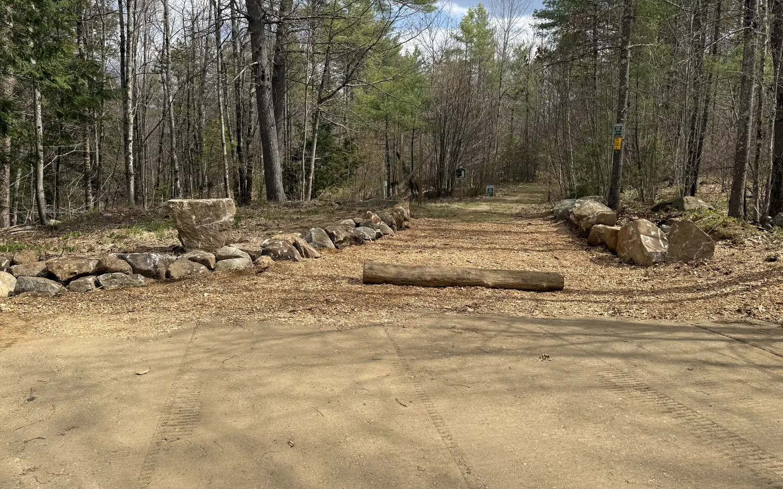 A freshly graded gravel pad cut into southern Maine woods