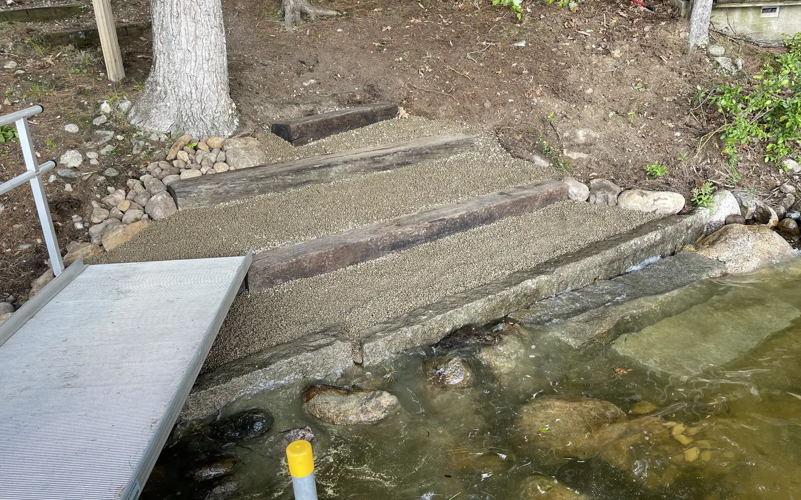 Rebuilt stone shoreline steps beside calm lake water
