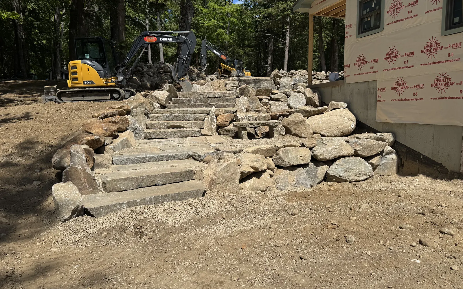 J. Mapes excavators setting granite steps and boulder walls at a new build